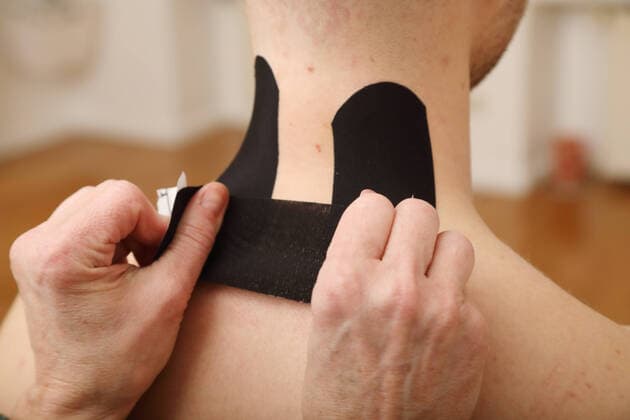 22.11.2020, Berlin, GER - Kinesio-Tapes werden auf menschliche Haut geklebt. (MR=yes, Alltag, alternativ, aufbringen, aufkleben, behandeln, Behandlung, Behandlungsmethode, Berlin, Detail, Detailaufnahme, deutsch, Deutschland, entspannen, Entspannung, Europa, europaeisch, Gesellschaft, Gesundheit, Haende, Halsmuskulatur, Haut, Heilkunde, Humanmedizin, innen, Innenaufnahme, kaukasisch, Kinesio-Pflaster, Kinesio-Tape, Kinesio-Tapes, Kinesio-Taping, Kinesiologie, Kinesiologie-Taping, Kinesiologisches Taping, Kinesiopflaster, Kinesiotapes, Klebebaender, Klebeband, kleben, Muskulatur, Pflaster, Pflasterstreifen, Physio, Physiotherapie, QF, Querformat, Schmerzlinderung, Selbstheilungskraefte aktivieren, Taping, Therapie, Verpannung, verspannt, Wel