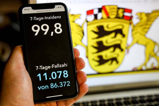 Coronavirus in Deutschland - Covid-19-Dashboard des Robert Koch-Institut DEU, Deutschland, Baden-Württemberg, 21.03.2021: Die 7-Tage-Inzidenz für das Bundesland (Fälle letzte 7 Tage 100.000 EW) wird auf einem iPhone angezeigt, im Hintergrund das Landeswappen