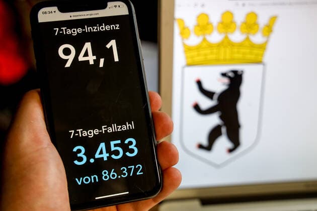 Coronavirus in Deutschland - Covid-19-Dashboard des Robert Koch-Institut DEU, Deutschland, Berlin, 21.03.2021: Die 7-Tage-Inzidenz für das Bundesland (Fälle letzte 7 Tage 100.000 EW) wird auf einem iPhone angezeigt, im Hintergrund das Landeswappen