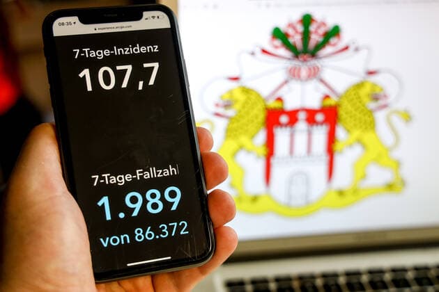 Coronavirus in Deutschland - Covid-19-Dashboard des Robert Koch-Institut DEU, Deutschland, Hamburg, 21.03.2021: Die 7-Tage-Inzidenz für das Bundesland (Fälle letzte 7 Tage 100.000 EW) wird auf einem iPhone angezeigt, im Hintergrund das Landeswappen