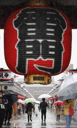 Virus emergency lifting People walk in the rain on Nakamise shopping street in Tokyo s Asakusa area on March 21, 2021, ahead of the scheduled lifting of the coronavirus state of emergency at the end of the day. 