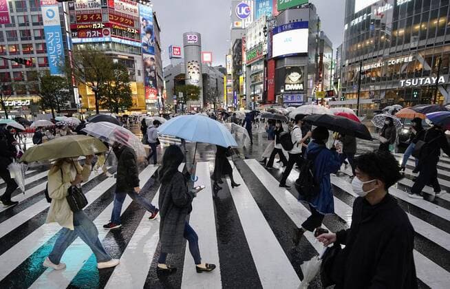 Virus emergency lifting People wearing face masks walk in the rain in Tokyo s Shibuya area on March 21, 2021, ahead of the scheduled lifting of the coronavirus state of emergency at the end of the day. 