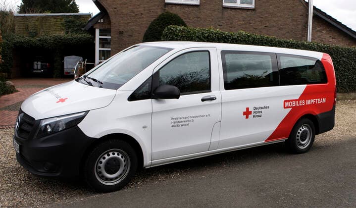DRK Einsatzfahrzeug Mobiles Impfen Einsatzfahrzeug des DRK Wesel mit der Aufschrift Mobiles Impfteam. Das Fahrzeug wird genutzt zum Transport der Impfdosen zu den Impfzentren oder ambulanten Impforten. Das Fahrzeug steht vor einem Privathaus. Moers Deutschland Nordrhein-Westfalen NRW