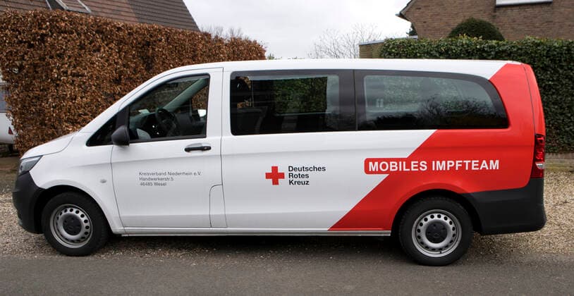 DRK Einsatzfahrzeug Mobiles Impfen Einsatzfahrzeug des DRK Wesel mit der Aufschrift Mobiles Impfteam. Das Fahrzeug wird genutzt zum Transport der Impfdosen zu den Impfzentren oder ambulanten Impforten. Das Fahrzeug steht vor einem Privathaus. Moers Deutschland Nordrhein-Westfalen NRW