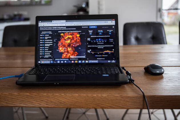 Bamberg, Deutschland 21. Maerz 2021: Auf einem Tisch in einer Wohnung steht ein aufgeklappter Laptop, auf dem Bildschirm ist die Seite vom Robert Koch-Institut mit den aktuellen COVID-19 Fallzahlen zu sehen. Bayern Copyright: xFotostandx xK.xSchmittx
