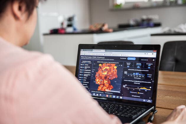 Bamberg, Deutschland 21. Maerz 2021: Eine Person schaut auf einen aufgeklappten Laptop, auf dem Bildschirm ist die Seite vom Robert Koch-Institut mit den aktuellen COVID-19 Fallzahlen zu sehen. Bayern Copyright: xFotostandx xK.xSchmittx