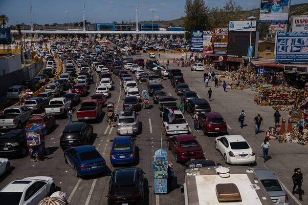 Vehicles wait in line at the Mexico-Unites States border to leave Tijuana, Mexico and enter the United States on Sunday, March 21, 2021. Biden has pledged to take new steps to address the surge of migrants on the border since he took office.  TIJ2021032101 ARIANAxDREHSLER