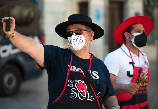 March 23, 2021, Malaga, Spain: A protester wearing a mask takes a selfie at Plaza de la Constitucion square during the demonstration..Employees from S.O.S Souvenirs association in Malaga, who work in tourists stores of souvenirs, demand the Spanish government sector survival facing fall incomes due to coronavirus pandemic. Many tourist stores and shops have had to close after restrictions of tourist sector and arrivals of tourists in Spain. Malaga Spain - ZUMAs197 20210323_zaa_s197_001 Copyright: xJesusxMeridax