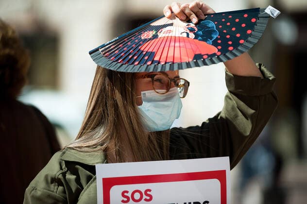 March 23, 2021, Malaga, Spain: A protester wearing a mask holds a placard at Plaza de la Constitucion square during the demonstration..Employees from S.O.S Souvenirs association in Malaga, who work in tourists stores of souvenirs, demand the Spanish government sector survival facing fall incomes due to coronavirus pandemic. Many tourist stores and shops have had to close after restrictions of tourist sector and arrivals of tourists in Spain. Malaga Spain - ZUMAs197 20210323_zaa_s197_003 Copyright: xJesusxMeridax
