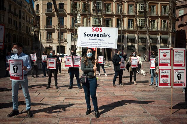 March 23, 2021, Malaga, Spain: Protesters wearing masks hold placards at Plaza de la Constitucion square during the demonstration..Employees from S.O.S Souvenirs association in Malaga, who work in tourists stores of souvenirs, demand the Spanish government sector survival facing fall incomes due to coronavirus pandemic. Many tourist stores and shops have had to close after restrictions of tourist sector and arrivals of tourists in Spain. Malaga Spain - ZUMAs197 20210323_zaa_s197_005 Copyright: xJesusxMeridax