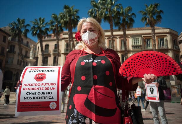 March 23, 2021, Malaga, Spain: A protester wearing a mask holds a placard at Plaza de la Constitucion square during the demonstration..Employees from S.O.S Souvenirs association in Malaga, who work in tourists stores of souvenirs, demand the Spanish government sector survival facing fall incomes due to coronavirus pandemic. Many tourist stores and shops have had to close after restrictions of tourist sector and arrivals of tourists in Spain. Malaga Spain - ZUMAs197 20210323_zaa_s197_007 Copyright: xJesusxMeridax