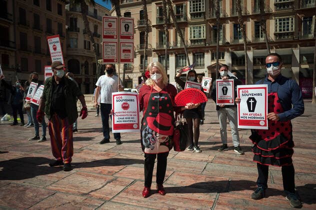 March 23, 2021, Malaga, Spain: Protesters wearing masks hold placards at Plaza de la Constitucion square during the demonstration..Employees from S.O.S Souvenirs association in Malaga, who work in tourists stores of souvenirs, demand the Spanish government sector survival facing fall incomes due to coronavirus pandemic. Many tourist stores and shops have had to close after restrictions of tourist sector and arrivals of tourists in Spain. Malaga Spain - ZUMAs197 20210323_zaa_s197_009 Copyright: xJesusxMeridax