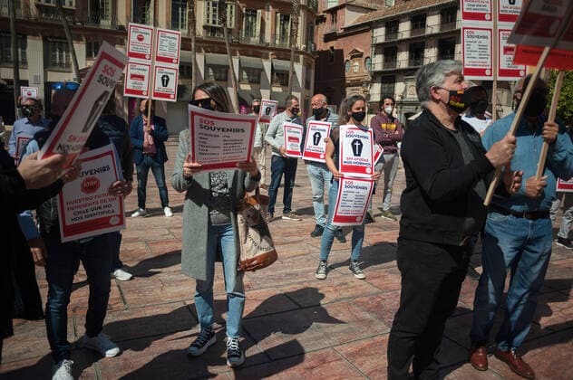 March 23, 2021, Malaga, Spain: Protesters wearing masks hold placards at Plaza de la Constitucion square during the demonstration..Employees from S.O.S Souvenirs association in Malaga, who work in tourists stores of souvenirs, demand the Spanish government sector survival facing fall incomes due to coronavirus pandemic. Many tourist stores and shops have had to close after restrictions of tourist sector and arrivals of tourists in Spain. Malaga Spain - ZUMAs197 20210323_zaa_s197_010 Copyright: xJesusxMeridax