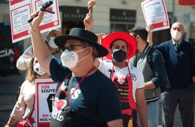 March 23, 2021, Malaga, Spain: Protesters wearing masks hold placards at Plaza de la Constitucion square during the demonstration..Employees from S.O.S Souvenirs association in Malaga, who work in tourists stores of souvenirs, demand the Spanish government sector survival facing fall incomes due to coronavirus pandemic. Many tourist stores and shops have had to close after restrictions of tourist sector and arrivals of tourists in Spain. Malaga Spain - ZUMAs197 20210323_zaa_s197_011 Copyright: xJesusxMeridax