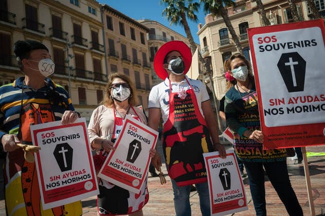 March 23, 2021, Malaga, Spain: Protesters wearing masks hold placards at Plaza de la Constitucion square during the demonstration..Employees from S.O.S Souvenirs association in Malaga, who work in tourists stores of souvenirs, demand the Spanish government sector survival facing fall incomes due to coronavirus pandemic. Many tourist stores and shops have had to close after restrictions of tourist sector and arrivals of tourists in Spain. Malaga Spain - ZUMAs197 20210323_zaa_s197_013 Copyright: xJesusxMeridax