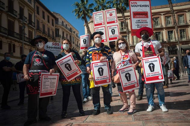 March 23, 2021, Malaga, Spain: Protesters wearing masks hold placards at Plaza de la Constitucion square during the demonstration..Employees from S.O.S Souvenirs association in Malaga, who work in tourists stores of souvenirs, demand the Spanish government sector survival facing fall incomes due to coronavirus pandemic. Many tourist stores and shops have had to close after restrictions of tourist sector and arrivals of tourists in Spain. Malaga Spain - ZUMAs197 20210323_zaa_s197_017 Copyright: xJesusxMeridax