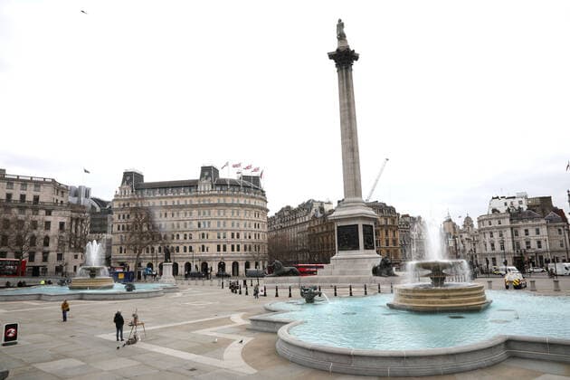 An artist stops painting and a few people pause during the moment of reflection in a very quiet Trafalgar Square. Today marks the first anniversary of the start of UK lockdown restrictions because of the COVID-19 Coronavirus pandemic. A national minute s silence at 12.00pm marks the moment of reflection. London is pictured today (March 23, 2021), on the anniversary of the first Coronavirus lockdown. 