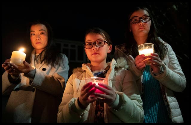 . 23 03 2021. Tonbridge, United Kingdom. Liya Sheehy and her children Lucy (9) and Sophie (11) take part in the beacon of remembrance outside their home in Tonbridge, Kent as part of the National Day of Reflection on the first anniversary of the Covid 19 lockdown in the United Kingdom.  xStephenxLockx xi-Imagesx IIM-22074-0028