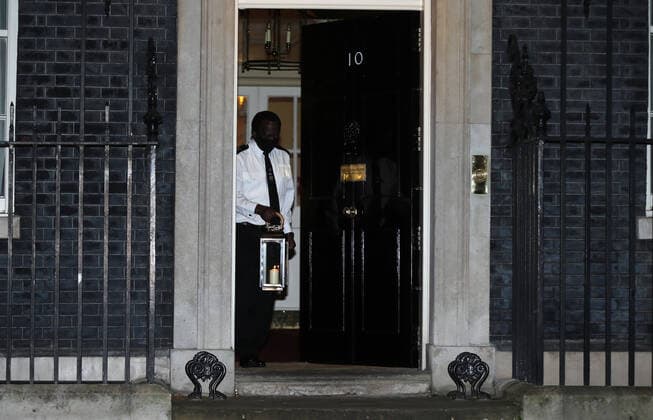 March 23, 2021, London, England, United Kingdom: A custodian puts a candle outside 10 Downing Street in memory of people who lost their lives during Coronavirus pandemic in the first anniversary of lockdown in the UK. More than 126 thousand people lost their lives in the country due to Covid-19. London United Kingdom - ZUMAs262 20210323_zip_s262_033 Copyright: xTayfunxSalcix