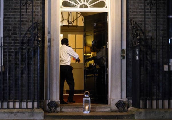 March 23, 2021, London, England, United Kingdom: A custodian puts a candle outside 10 Downing Street in memory of people who lost their lives during Coronavirus pandemic in the first anniversary of lockdown in the UK. More than 126 thousand people lost their lives in the country due to Covid-19. London United Kingdom - ZUMAs262 20210323_zip_s262_039 Copyright: xTayfunxSalcix