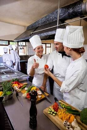 Group of chefs interacting with each other in kitchen Group of chefs interacting with each other in kitchen at hotel, model released, , property released, Cork, Ireland, 04.01.2019, 1210097.jpg, chef, occupation, professional, profession, skill, expertise, job, trainee, catering, coworker, staff, chefs white, chefs hat, chefs scarf, uniform, team, teamwork, together, smart, handsome, beautiful, standing, smiling, happy, cheerful, holding, gesturing, thumbs up, hand sign, cooking, preparing, knife, chopping board, cutting board, tomato, vegetable, raw, oragnic, food, freshness, hotel, restaurant, kitchen, commercial, hospitality, service, business, retail, food and drink industry 40s, Mature Adult, Man, Male, Caucasian, 30s, Mid Adult, Woma