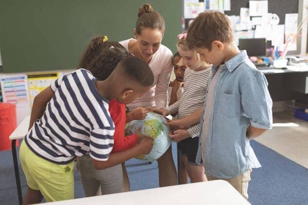 Schoolteacher explaining to his school kids the earth globe in classroom Front view of a schoolteacher explaining to his school kids the earth globe in classroom at school, model released, , property released, Cork, Ireland, 05.02.2019, 1238612.jpg, school, classroom, desk, bench, casual clothing, school kid, schoolboy, schoolgirl, student, classmate, schoolteacher, schoolmaster, chalkboard, study, studying, learning, standing, explaining, assisting, guidance, interacting, attentive, focused, concentration, globe, map, atlas, cartography, geography, countries, location, discover, explore, childhood, innocence, development, education, academic, information, knowledge, lifestyle, elementary, intelligent, intelligence, wisdom, together, group
