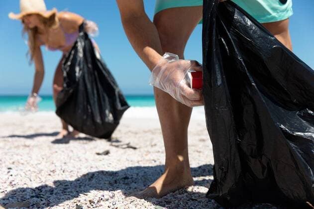 IMAGO Creative: Klimawandel - Umwelterziehung Young couple picking up the rubbish Mid section of a Caucasian couple on the beach with blue sky and sea in the background, picking up the rubbish to trash bags, model released, , property released, Cape Town, South Africa, 21.11.2019, 1310028.jpg, people,couple,together,interacting,bonding,romantic,real people,enjoy,enjoying,pleasure,lifestyle,free time,holidays,vacation,weekend,activity,relaxing,fun,health,healthy,outdoorsy,fit,leisure,beach,coast,coastal,sea,ocean,sand,sunny,summer,water,blue sky,eco-friendly,green,recycling,volunteer,volunteering,environment,cleaning,awareness,social responsibility,community,community spirit,helping,rubbish,collecting,trash,organised,teamwork,sun hat,millennial Young Adult,Woman,Female,Caucasian,Man,Ma