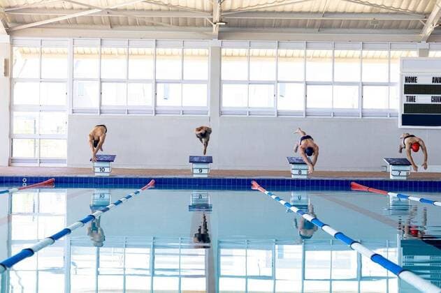 IMAGO Creative: Sport Dichotomien - Land und Wasser Swimmers plunging in the pool Front view of four male swimmers at swimming pool, jumping from starting blocks, plunging into water. Swimmers training hard for competition., model released, , property released, Cape Town, South Africa, 01.12.2019, 1313257.jpg, people,plunging,jumping,jump,lane,starting,starting block,race,competition,competing,water,together,real people,active,athletic,muscular,muscle,toned,exercise,fit,fitness,development,improvement,progress,achievement,strong,strength,flexibility,flexible,health,healthy,physical,lifestyle,training,sportswear,swimmer,swimming pool,swimming,swimming cap,swimming goggles,athlete Young Adult,Man,Male,Caucasian,Mid Adult Indoors,Front view,Focus on Foreground,Looking down,Four objects,Day,Ful