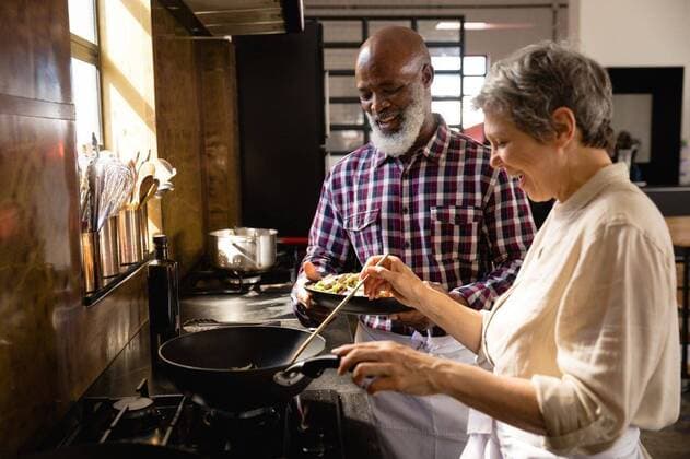 Old chefs cooking together Side view of a senior Caucasian woman and a senior African American man at a cookery class talking, the woman cooking with a wok and the man holding a dish of chopped vegetables and smiling, model released, , property released, Cape Town, South Africa, 05.12.2019, 1317544.jpg, real people, discussing, discussion, dish, vegetables, pan, wok, cooking, work station, team, together, restaurant, business, food, kitchen, cookery, cuisine, culinary, catering, profession, job, experience, skill, busy, service, professional, confident, work, worker, working, preparation, preparing, making, chef, head chef, class, training, student, teacher, teaching, learning, education, workshop, cook, active seniors, retirement Mature A