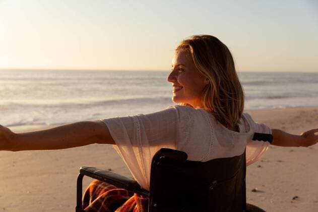 IMAGO Creative: NGO, Rehabilitation und Gesundheitswesen Smiling woman on wheelchair with her arms wide open at the beach Attractive blonde Caucasian woman enjoying time at the beach at sundown, sitting on a wheelchair, widening her arms, with sunset sky and sea in the background. Summer tropical beach vacation., model released, , property released, Cape Town, South Africa, 25.02.2020, 1351282.jpg, people,disabled,disability,wheelchair,widening,arms,happy,smiling,real people,gen z,generation z,holidays,vacation,beach,sea,sand,tropical,coast,summer,seaside,enjoying,sun,leisure,freedom,free time,time off,relaxing,escapism,weekend,relax Young Adult,Woman,Female,Caucasian