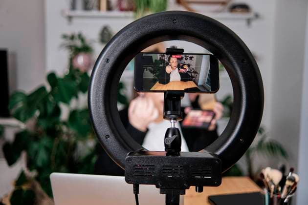 Woman applying make-up while filming make-up tutorial at home model released Symbolfoto property released ASGF00036