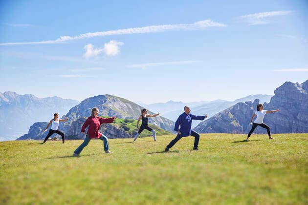 Man and women practicing yoga on meadow against sky model released Symbolfoto CVF01667