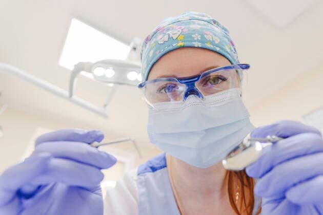 Portrait of female dentist wearing protective face mask leaning toward camera model released Symbolfoto property released EYAF01553