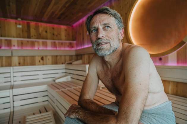 Mature man with blue eyes looking away while sitting at finnish sauna model released Symbolfoto property released MFF07360