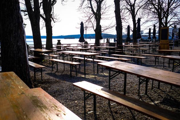 Geschlossener Biergarten 25.03.2021: Ein geschlossener Biergarten am Ufer des Ammersees bei Stegen (Inning am Ammersee; Oberbayern) mit Blick in Richtung Alpen. Inning Bayern Deutschland
