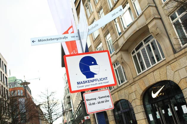 An einem Laternenpfahl vor der Geschäftsstraße Spitalerstraße ist ein Hinweisschild angebracht, dass hier Maskenpflicht besteht. Innenstadt Hamburg