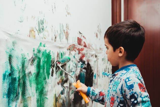 Child playing to paint colors the wall of his house with roller and acrylic paint Ceuta, CE, Spain CR_VIMU210325-687548-01 ,model released, Symbolfoto
