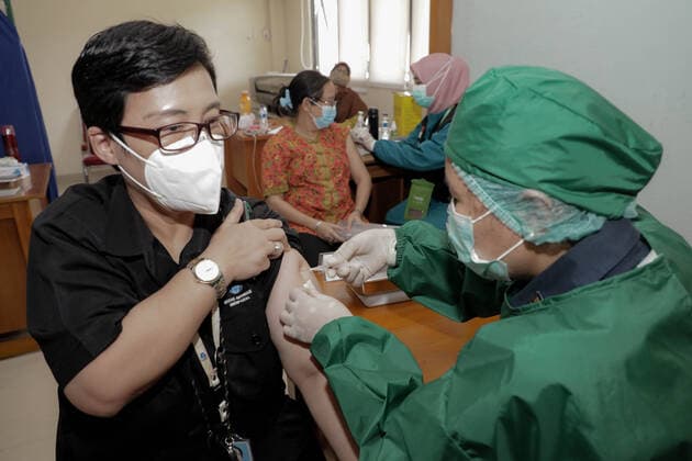 March 25, 2021, Depok, Jawa Barat, Indonesia: A healthcare worker injects a dose of Sinovac COVID-19 vaccine to a worker during a mass vaccination drive for the public sector workers at Geospatial Information Agency Office in Bogor..Indonesia is currently in the second phase of mass covid-19 vaccination. In this second phase, the Indonesian government targets 38.5 million people, including 16.9 million workers in public sectors and 21.6 million elderly citizens, as well as workers in hospitality, transportation, tourism sectors and mass media workers. Depok Indonesia - ZUMAs197 20210325_zaa_s197_082 Copyright: xRisaxKrisadhix