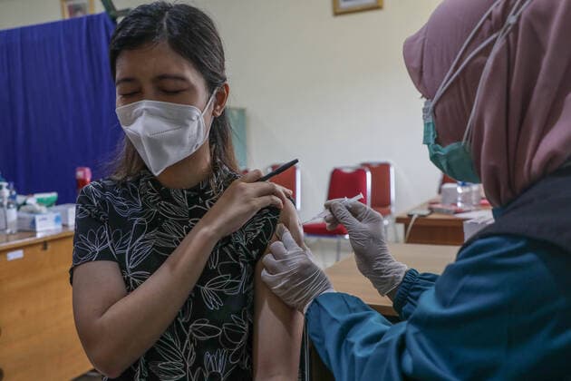 March 25, 2021, Depok, Jawa Barat, Indonesia: A healthcare worker injects a dose of Sinovac COVID-19 vaccine to a worker during a mass vaccination drive for the public sector workers at Geospatial Information Agency Office in Bogor..Indonesia is currently in the second phase of mass covid-19 vaccination. In this second phase, the Indonesian government targets 38.5 million people, including 16.9 million workers in public sectors and 21.6 million elderly citizens, as well as workers in hospitality, transportation, tourism sectors and mass media workers. Depok Indonesia - ZUMAs197 20210325_zaa_s197_084 Copyright: xRisaxKrisadhix