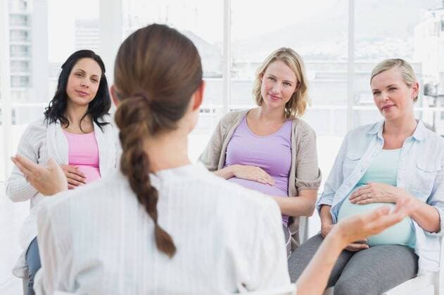 Pregnant women listening to gesturing doctor at antenatal class Pregnant women listening to gesturing doctor at antenatal class at the hospital, model released, Cape Town, South Africa, 19.11.2013, 297142.jpg, hospital, clinic, window, bright, antenatal class, group, discussion, support, sitting, listening, doctor, obstretcican, pregnant, pregnancy, expectant, expecting, belly, maternity, prenatal care, happy, smiling, cheerful, talking, communication, conversation, interacting, speaking, midwife 30s, Mid Adult, Woman, Female, Caucasian, Man, Male, 30-34 Years, Mid Adult Women, Caucasian Ethnicity, 35-39 Years, Mid Adult Men Indoors,Over the shoulder view,Day,Half length