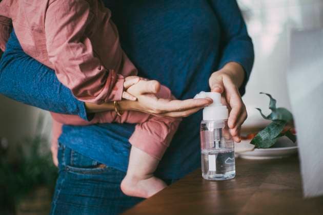Midsection of mother and daughter applying sanitizer at home Sweden, Stockholm, model released, property released Copyright: xMaskotx , MA85625
