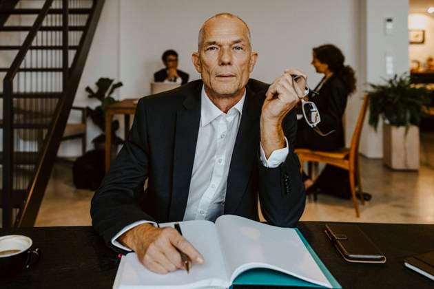 IMAGO Creative: Menschen in Berlin - Generationen Confidence businessman with dairy at table in office Germany, Berlin, model released, property released Copyright: xMaskotx , MA85289