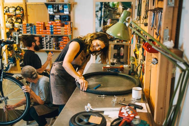 Male and female mechanics repairing bicycle in repair shop Sweden, Stockholm, model released, property released Copyright: xMaskotx , MA85343
