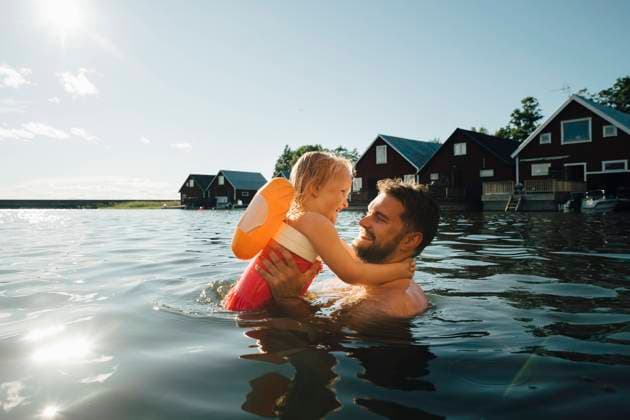 IMAGO Creative, Jahreszeit Sommer, Sommerferien IMAGO Creative: Vaterschaft IMAGO Creative: Dichotomien, Reflexionen Side view of cheerful daughter with father in lake during vacations Sweden, Tierp, model released Copyright: xMaskotx , MA85508