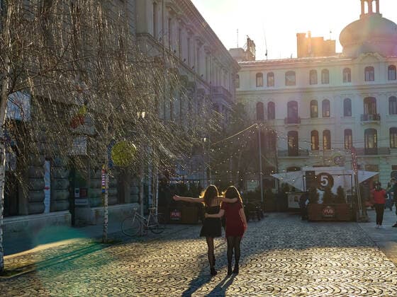 Two girls dancing in the Old town with restaurants and bars with tourists and local people in Bucharest, Romania on March 27, 2021.