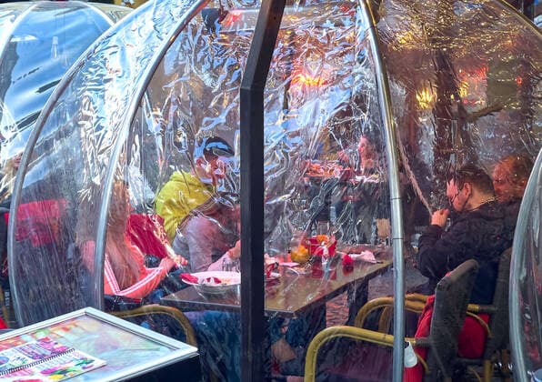 Corona bubbles, protective covers made of plastic in the Old town with restaurants and bars with tourists and local people in Bucharest, Romania on March 27, 2021.