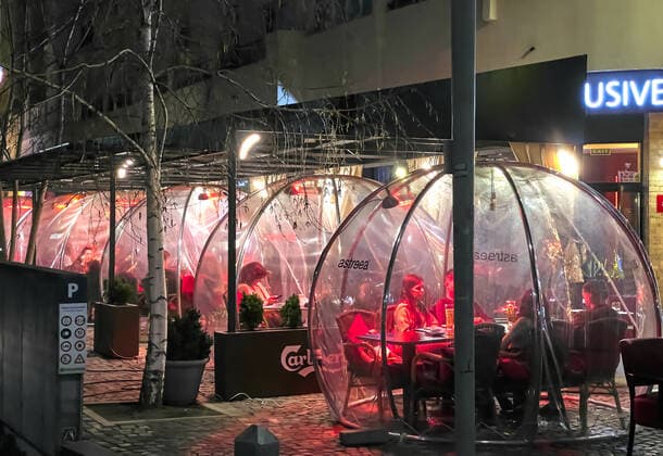 Corona bubbles, protective covers made of plastic in the Old town with restaurants and bars with tourists and local people in Bucharest, Romania on March 27, 2021.