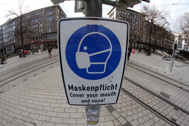 Ein Schild mit Piktogramm und Aufschrift Maskenpflicht hängt in der weitgehend menschenleeren Fußgängerzone und Einkaufsstraße Planken in der Innenstadt von Mannheim, Baden Württemberg, Deutschland