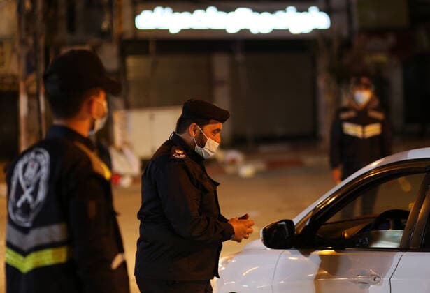 (210328) -- GAZA, March 28, 2021 -- Palestinian police officers work at a checkpoint in the Gaza Strip city of Khan Younis, March 27, 2021. The Hamas-run Interior Ministry imposed a full lockdown on Saturday all over the Gaza Strip at night-time from 9:00 PM due to increasing numbers of COVID-19 infection. (Photo by Xinhua) MIDEAST-GAZA-KHAN YOUNIS-COVID-19 YasserxQudih 