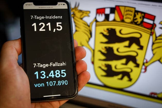 Coronavirus in Deutschland - Covid-19-Dashboard des Robert Koch-Institut DEU, Deutschland, Baden-Württemberg, 28.03.2021: Die 7-Tage-Inzidenz für das Bundesland (Fälle letzte 7 Tage 100.000 EW) wird auf einem iPhone angezeigt, im Hintergrund das Landeswappen